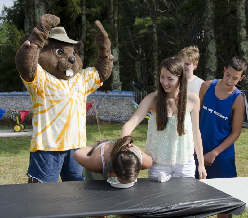 Buck Chuck cheers on Nicole Correia, 14, while her friend Catherine Wheeler, 15, keeps her friend's hair free of pie. After tying for second place, Correia went in for a second round and took home the red ribbon. BY GEORGIA SPARLING